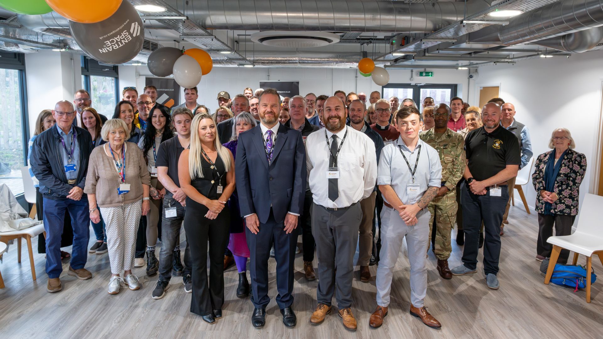 Community gathering inside Entrain Space with residents, staff and supporters